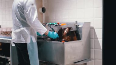 Şekerleme makinesindeki çikolatanın sıcaklığını kontrol eder. Lezzetli ikramlar için mükemmel bir tutarlılık sağlar. Çikolata yapımındaki hassasiyet ve özeni vurguluyor..