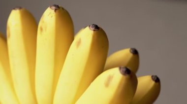 Bir grup olgun sarı muzun yakın plan çekimi. Muzlar bir küme halinde dizilir ve doğal ışıkla aydınlatılır. Canlı ve enerjik bir görsel yaratmak için mükemmel..