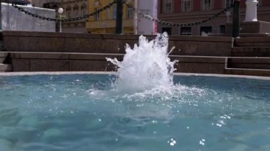 Güneşli bir günde ferahlatıcı bir çeşme su sıçratır ve şehir ortamında sakin bir kaçış sunar. Dinamik su hareketi şehir meydanına canlı bir dokunuş katıyor. Yazı tasvir etmek için ideal