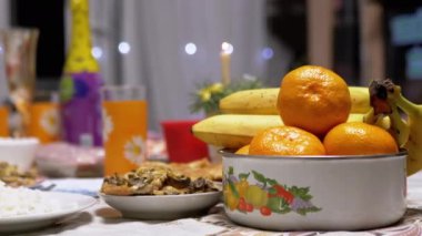 Nefis bir yemek masası, lezzetli yemekler, meyveler ve şenlikli süslemelerle birlikte. Bu davet sahnesi tatil sezonunun sıcaklığını ve neşesini yansıtıyor..