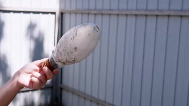 Gri beton bir yüzeyin paslı metal bir köşesine yakın plan taş bir duvara karşı. Bu çürümeyi, ihmalkarlığı ve zamanın geçişini simgeler..