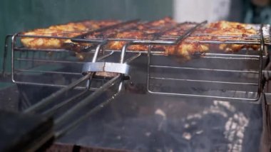 Sulu tavuk parçaları ızgarada cızırdıyor, yağlar kömürlere damlıyor, aromalı dumanlar yaratıyor, açık hava yemekleri ve barbekü tarifleri için mükemmel.