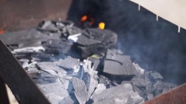 Izgarada yanan kömürün, alevlerin ve dumanın yakın çekimi. Yemek pişirme, ızgara, yaz ve yangın projeleri için mükemmel..