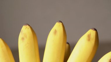 Sabit bir hayatta masanın üzerinde duran kahverengi benekli sarı muzların yakın çekimi. Kamera sorunsuz hareket ediyor..