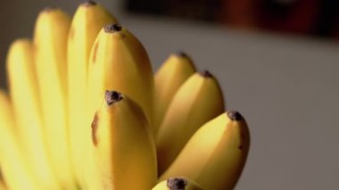 Taze sarı muzlar, bir demet halinde, yenmeye hazır. Bu görüntüler taze meyvenin güzelliğini gösteriyor. Sağlıklı besin seçeneklerini sergilemek için mükemmel..