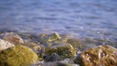 Sahildeki kayalara vuran dalgaların dinamik yakın çekimi suyun enerjisini ve hareketini yakalıyor..