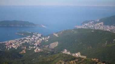 Budva kentinin havadan görünüşü, Montenegros Adriyatik kıyı şeridi, St. Nicholas Adası yer alıyor. Sakin deniz manzarası ve kıyı dağları. Seyahat, turizm ve belgesel projeleri için mükemmel..