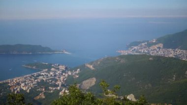 Karadağ kıyı şeridinin nefes kesici manzarası, adalar, tekneler ve açık mavi gökyüzüne karşı dolambaçlı bir yol. Seyahat, turizm ve belgesel projeleri için mükemmel..