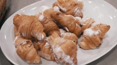 Basit ama baştan çıkarıcı bir tabak taze kruvasan. Hızlı bir kahvaltı ya da atıştırmalık için mükemmel. Altın rengi sıcak ve pul pul bir dokuyu işaret ediyor..