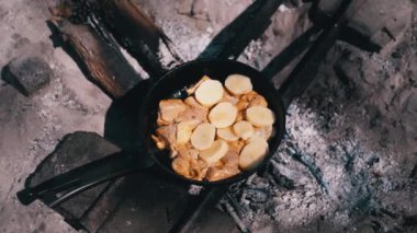 Tavuk ve patates bir kamp ateşinde tavada kızartılır. Vahşi doğada renk derecelendirme ile yemek hazırlıyorum..