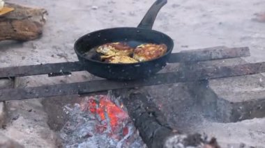 Kamp ateşinin üstünde balık kızartmak. Hayatta kalma kavramı, doğada yemek pişirme, kamp yapma ve yürüyüş. Turist, balıkçı ve avcıların yaşam tarzlarını temsil eden bir yemek..