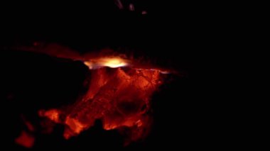 Yanan közler odun parçasının altında yoğun bir şekilde parlayarak sıcak ve davetkar bir atmosfer yaratır. Yemek pişirme, ızgara ve açık hava aktiviteleriyle ilgili projeler için harika..