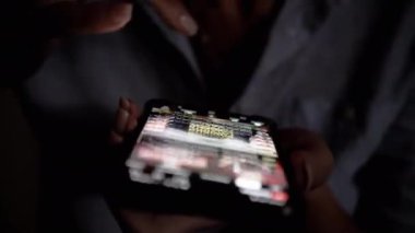 Loş bir odada, bir doktor tıbbi haberleri ve telefonundaki güncellemeleri inceliyor. Tıbbi, sağlık ve teknolojiyle ilgili projeler için ideal.