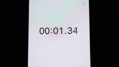 Akıllı telefon kronometresinin yukarı doğru giden dikey videosu. Zaman, ilerleme ve başarı konulu projeler için mükemmel..