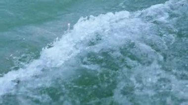 Bir tekneden: turkuaz Koman Gölü suyu dalgalanmaları ve köpükler, dinamik bir Arnavut deniz manzarası. Seyahat ve macera filmleri için ideal..