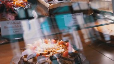 Kirazlı bir çikolatalı pasta bir kafe vitrininde güzelce sunulur. Yemek blogları, kafeler ve tatlı menüleri için ideal..