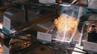 Fırın vitrinindeki pasta ve hamur işleri, çeşitliliği ve zanaatkarlığı ön plana çıkarıyor..