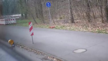 Kırmızı ve beyaz bariyerleri olan kapalı bir yol, tali yollar, ve yayalar, ağaçlık bir alanda bisiklet yolu. İnşaat, tali yol ve trafik yönetimi videoları için ideal.