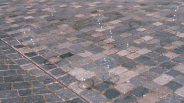 Sabun köpükleri bir kaldırım taşı caddesinde sürükleniyor ve zıplıyor, neşeli ve kaprisli bir sahne yaratıyor. Özgeçmiş, örtüşmeler ve çocukların içeriği için ideal.