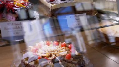 Bir kafede sergilenen, kiraz ve kremalı lezzetli görünümlü bir çikolatalı pasta. Fırın, kafe ve tatlı promosyonları için harika..