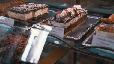 Yemek, seyahat ve fırın projeleri için mükemmel, cezbedici Alman pastaları ve pastalarıyla dolu bir vitrin..