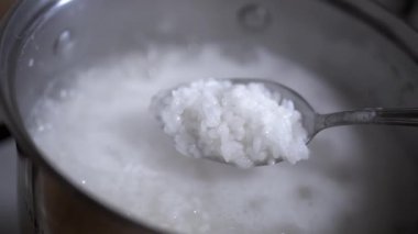 Bir kaşık dolusu pişmiş beyaz pirincin yakın çekimi. Yemek blogları ve yemek tarifi videoları için mükemmel..