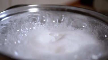 Ocağın üzerindeki bir tencerede kaynayan suyun yakın çekimi. Yemek pişirme, yemek hazırlama ve yemek tarifi videoları için mükemmel..