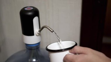 Elektrik pompasından bardağa akan su içme suyuna erişmek için uygun bir yol sağlıyor..