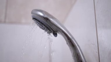 Banyodaki bir duş başlığından gelen su, hijyen ve günlük rutin projeler için uygun ferahlatıcı bir görsel yaratıyor..