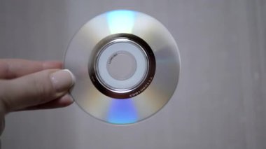 Bir el, yanardöner yüzeyini gösteren ve ışığı yansıtan bir CD 'yi tutar. Teknoloji, müzik veya veriyle ilgili projeler için harika.