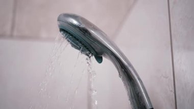 Duş başlığından fayanslara fışkıran su canlandırıcı bir görüntü oluşturur. Banyo ve yaşam tarzı temaları için ideal.