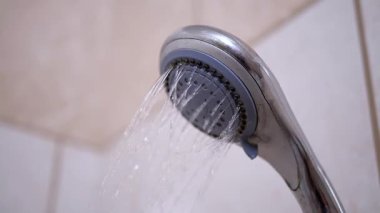 Duş başlığından gelen su akıntıları fayanslı banyo arka planına karşı, banyo, hijyen ve günlük görseller için ideal..