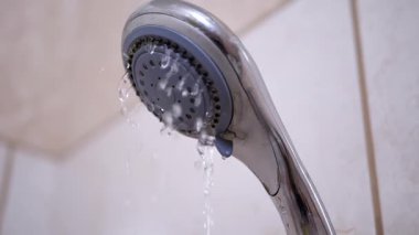 Duş başlığından akan su, banyo fayanslarına karşı sürekli bir akış oluşturuyor. Hijyen ve günlük rutin görseller için ideal..
