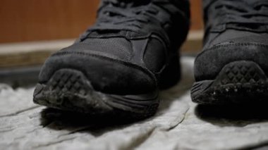 Yüzeyde biriken toz ve kiri vurgulayan kirli siyah spor ayakkabılarının yakın çekimi. Temizlik, onarım ve yaşam tarzı temaları için uygundur.