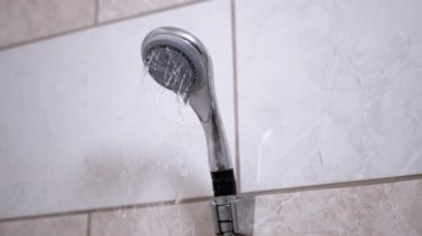 Kirli, paslı bir banyo musluğundan su akıyor. Eskimiş armatür ve fayanslar temizlik ya da onarım ihtiyacı olduğunu gösteriyor..