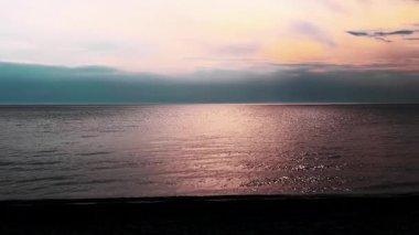 Suya yansıyan sıcak ışınlarla çarpıcı dramatik deniz batımı. Yumuşak bulutlar, altın, kırmızı güneş ışığı ile aydınlatılır, sakin bir atmosfer yaratır. Güneş ışığı Ege Denizi 'ndeki su yüzeyinden yansıyor.