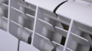 Beyaz bir radyatörün detaylı görüntüsü, tasarımını ve dokusunu gösteriyor. Ev geliştirme, ısıtma ve iç tasarım projeleri için ideal.