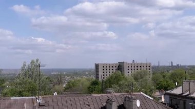 Şehrin eski bölümündeki evlerin çatısının penceresinden manzarayı izle. Şehrin üzerinde gri kümülüs bulutları asılı. Ufkun görüntüsü.