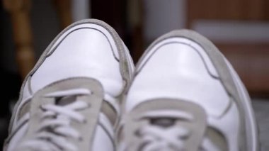 Bir çift beyaz spor ayakkabısının ayak parmaklarının yakından görünüşü, tasarımlarını ve dokularını vurguluyor. Ayakkabı, moda ve yaşam tarzı projeleri için ideal.