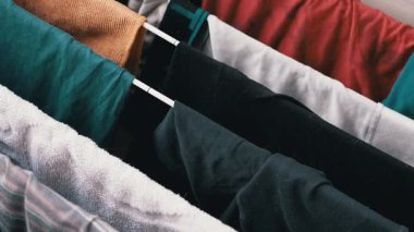 Kıyafetlerin yakın plan çekimleri elbise rafında kurulanması, günlük ihtiyaçların altını çizmek..