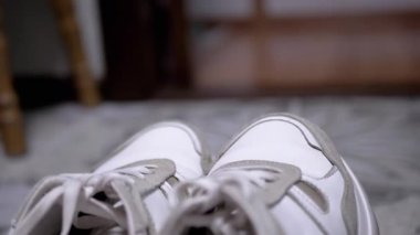 Gri süet aksanlı beyaz spor ayakkabıların detaylı görüntüsü, desen ve tasarım için mükemmel. Moda, ayakkabı ve ürün fotoğrafçılığı projeleri için ideal.