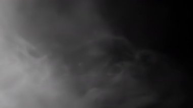 Abstract visuals consisting of dark fog and swirling smoke, which create mysterious patterns and intriguing forms