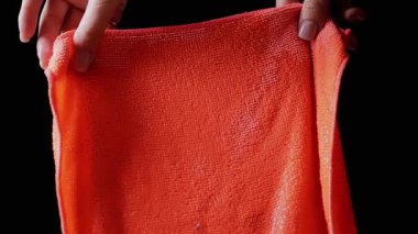 Water Streams Flowing Down Orange Microfiber Cloth On Black Background. Transparent Water Streams, Drops Falling Down, Empty Space. Slow Motion. Close-up. Flowing Water, Splashes. Cleaning Concept.