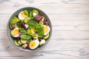 Keto dish - healthy green salad with arugula, tuna, mozzarella and eggs. 