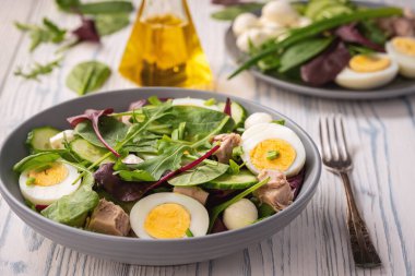 Keto dish - healthy green salad with arugula, tuna, mozzarella and eggs. 