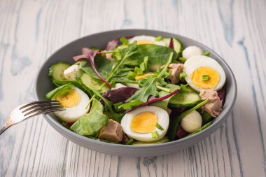 Keto dish - healthy green salad with arugula, tuna, mozzarella and eggs. 