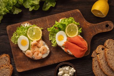 Kaynamış yumurtalı tost, salata, marul, limon salatası, karides ve füme somon..