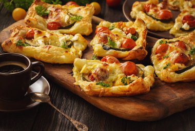 Crispy puff pastry mini tarts with zucchini, tomatoes and cheese. 