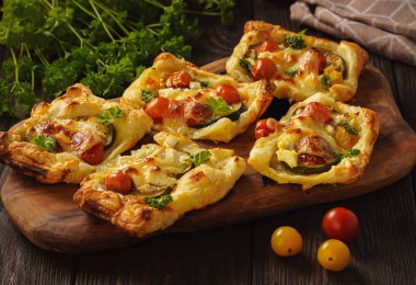 Crispy puff pastry mini tarts with zucchini, tomatoes and cheese. 