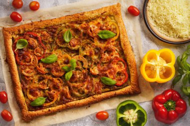 Homemade puff pastry pie with pesto, tomatoes and mozzarella like pizza caprese.   